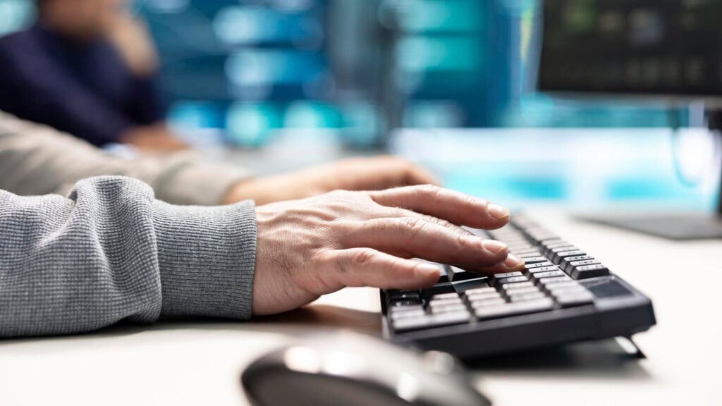 Hände eines Mitarbeiters, die eine Tastatur bedienen