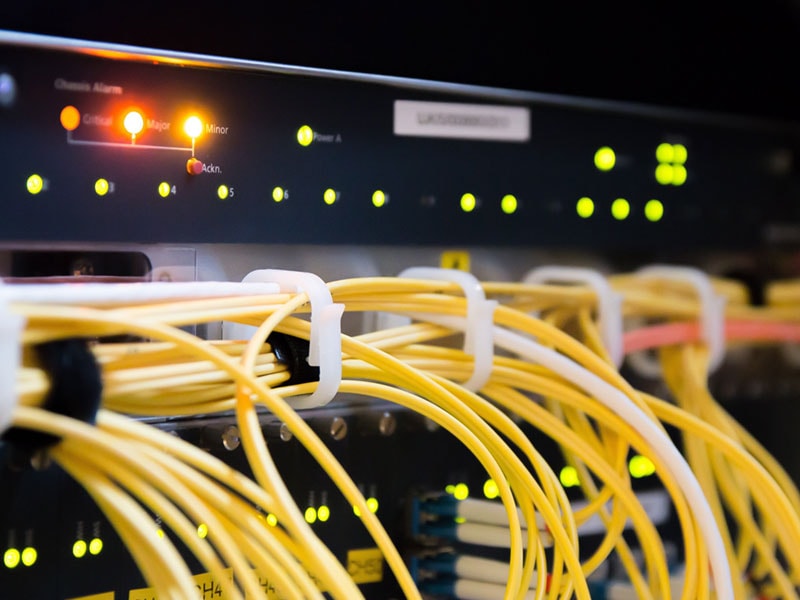 Rückansicht eines Servers mit vielen Kabeln und Leuchten